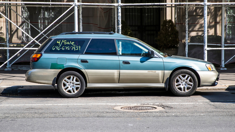 A side-profile view of a two-tone 2003 Subaru Outback Limited