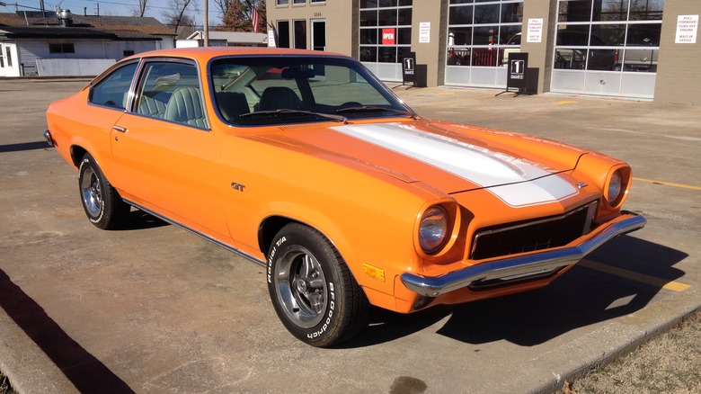 Front 3/4 shot of a orange Chevrolet Vega parked in a parking lot.