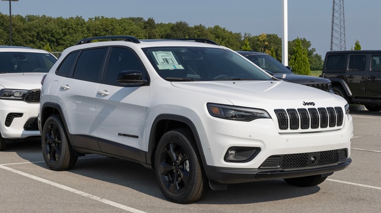 A white 2023 Jeep Cherokee parked in a dealership