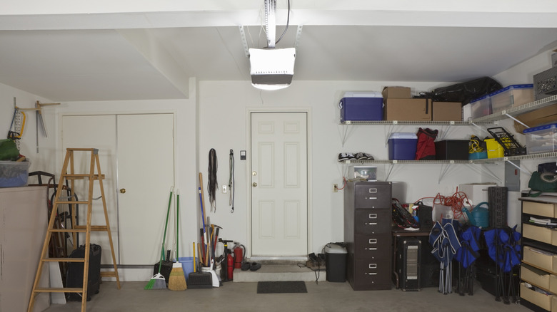 The interior of a two-car garage with tools, cleaning implements and a ladder stored inside
