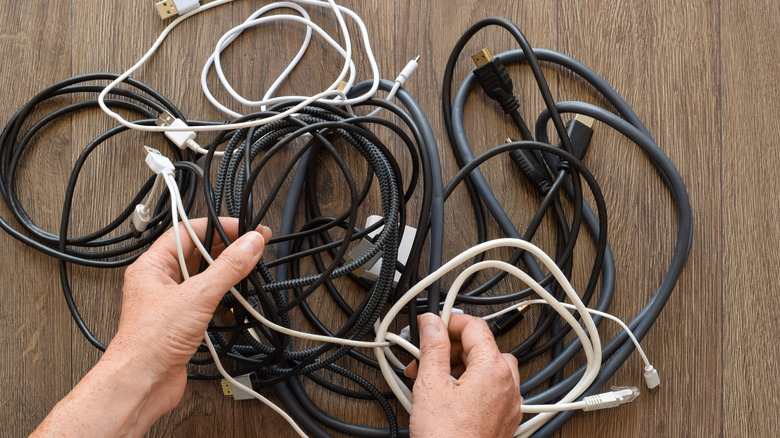 Person working through a jumble of cables.