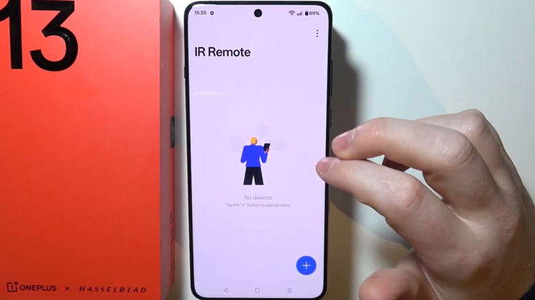 A person using a OnePlus 13 phone showing the IR remote feature