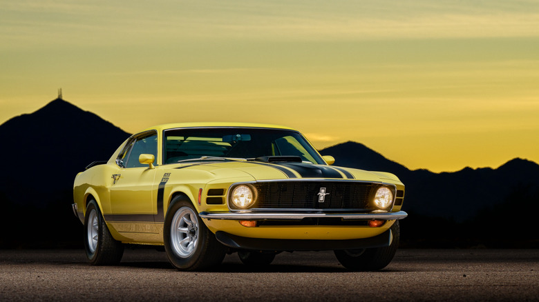 1969 Ford Mustang Boss 302 in yellow with lightweight wheels at sunset, front 3/4 view