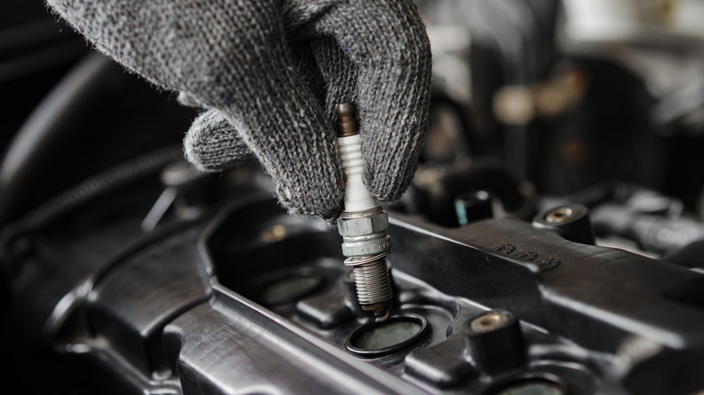 A person installing a spark plug.