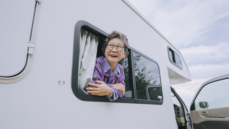 A woman looking out of an RV window.