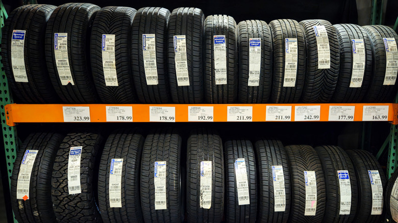 Rows of various brands of tires on display at a Costco store.