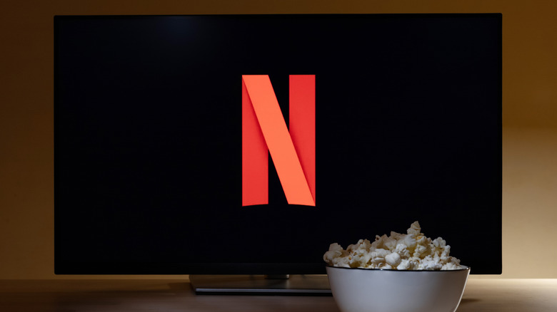A TV with the Netflix symbol and a white bowl of popcorn sitting in front of it