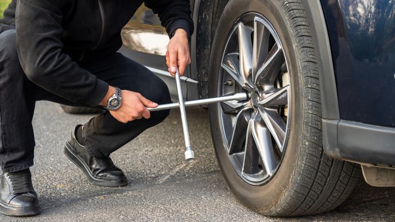 Man changing tire on side of road