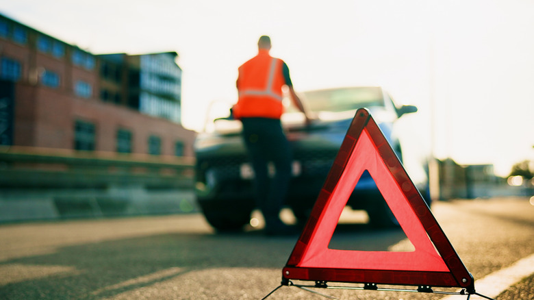 Car broken down with hazard sign placed