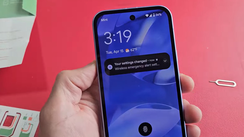 Close up of a person holding a Mint Mobile phone while being activated