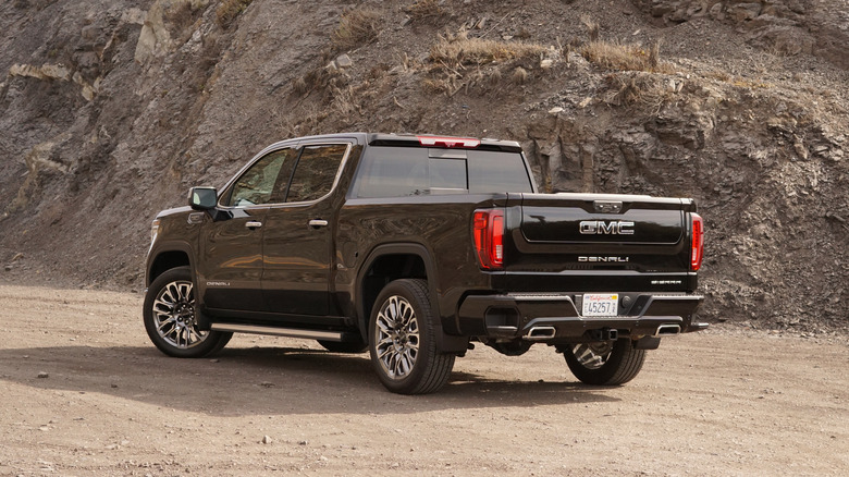 A black GMC Sierra 1500 Denali parked on a dirt road