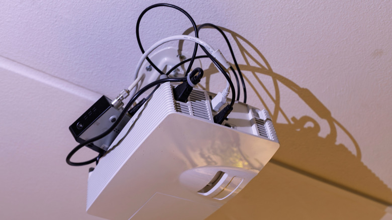 Projector mounted from ceiling with mess of cables attached