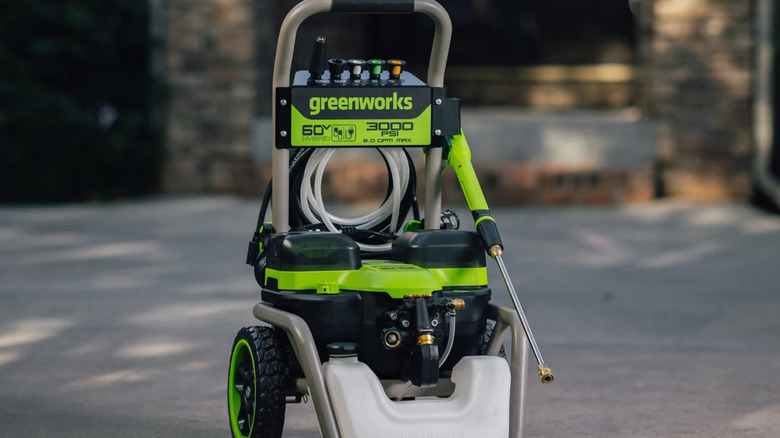 A Greenworks Corded/60V 3000-PSI 2.0 GPM Electric Pressure Washer sitting on a concrete driveway