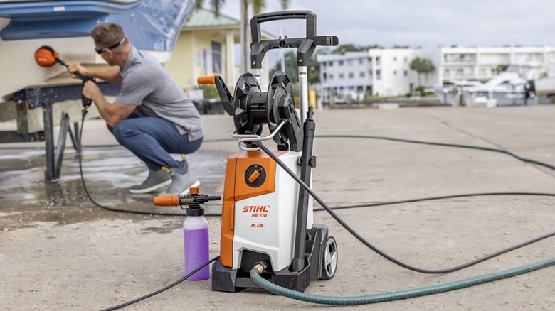A man using the Stihl RE 110 Plus pressure washer to clean a boat
