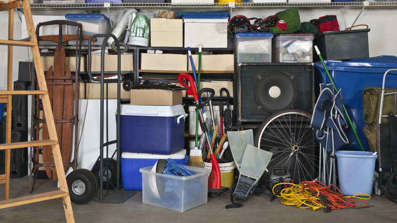 A messy, cluttered garage space full of boxes, coolers and more
