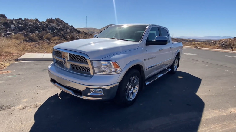 A silver 2012 Ram 1500 parked in a rural area.