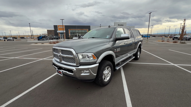 A gray 2013 Ram 2500 parked, car dealerships in the background.
