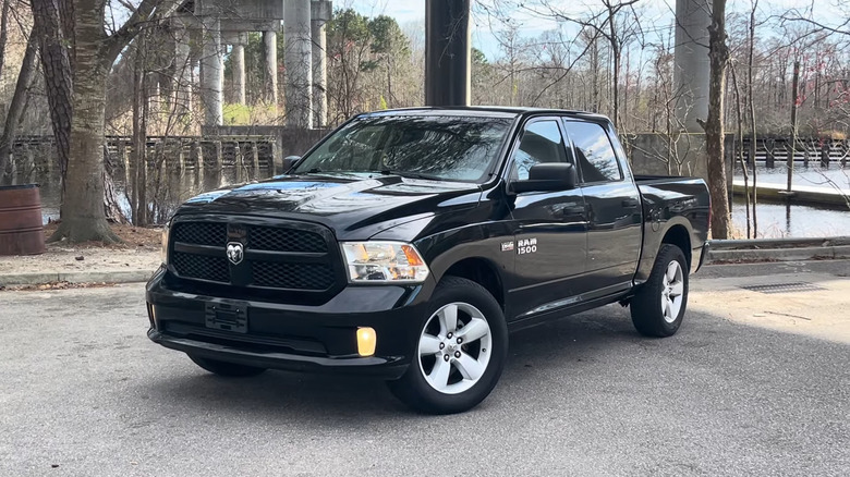 A black 2104 Ram 1500 parked next to water.
