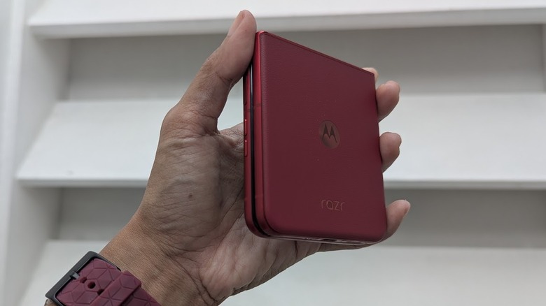Hand holding up a folded Motorola Razr Ultra 2025 against a white wall