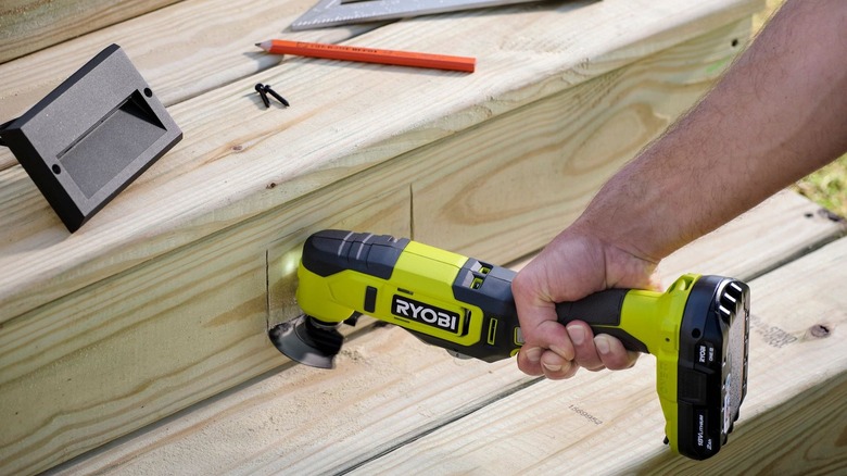 A person using Ryobi oscillating multi-tool