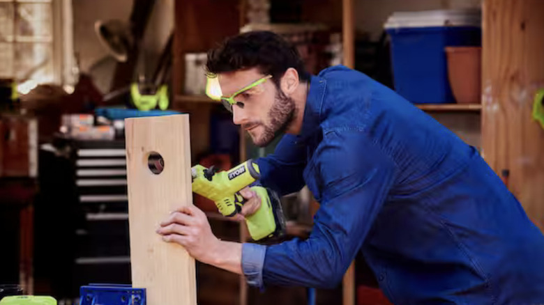 A man using a Ryobi belt sander on a woodworking project