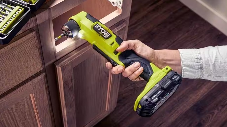 Hand holding 18V ONE+ HP Compact Brushless 3/8 in. Right Angle Drill while screwing inside a cabinet