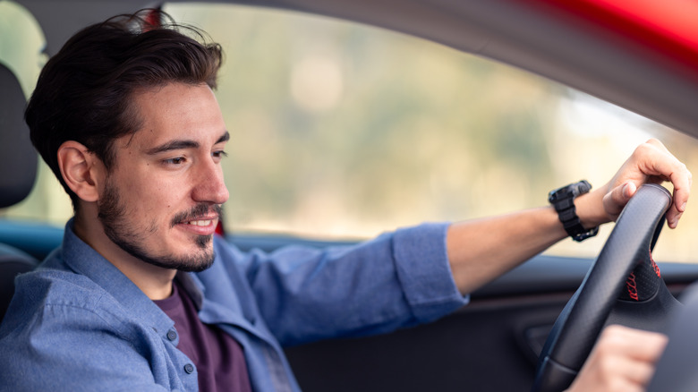 A man in a car wearing a watch.