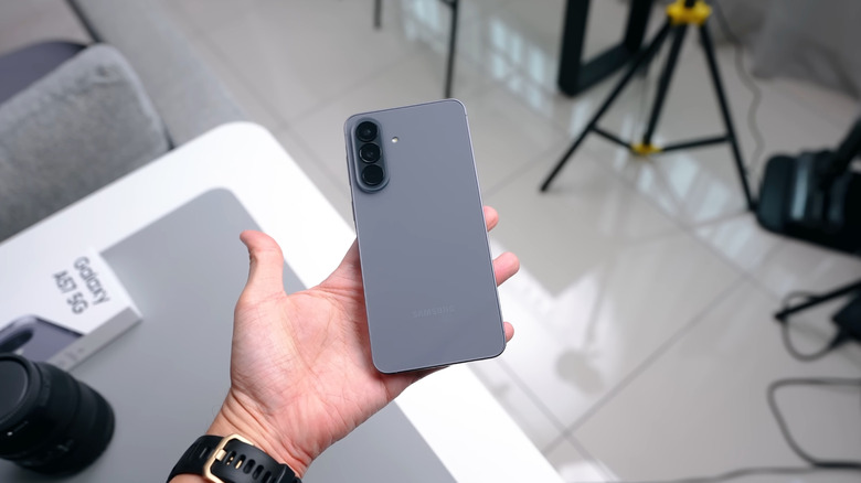 A person holding the Samsung Galaxy A57 5G in the Gray colorway