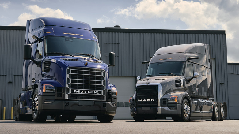 Mack Pioneer and Anthem semi trucks parked on tarmac in industrial setting