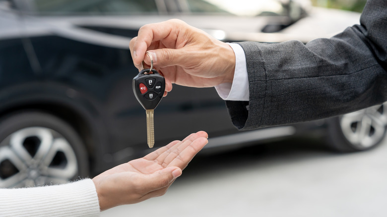 Man handing car keys to woman