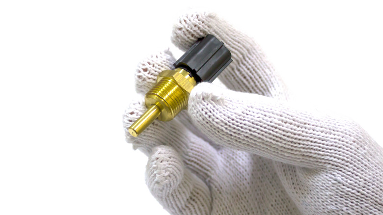 Hand holding coolant temperature sensor