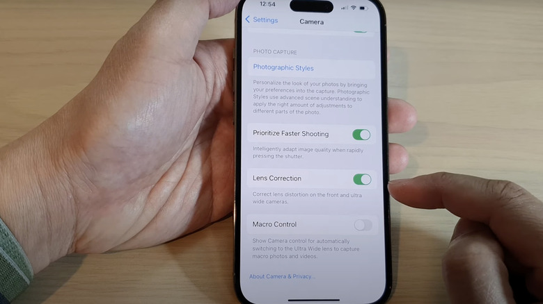 person turning on lens correction on iPhone