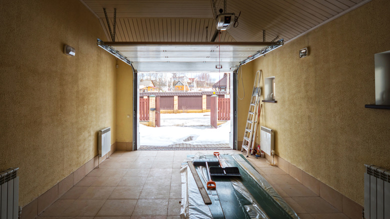 Picture showing tools inside of a garage with snow outside