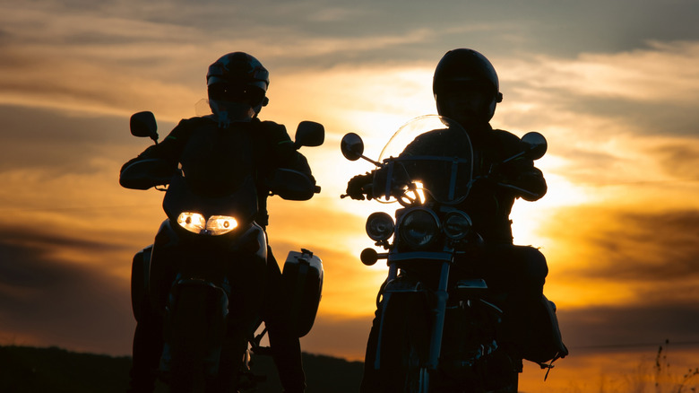 Silhouette of two motorcycle riders on the road