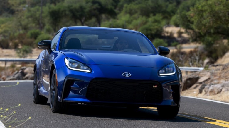 A blue 2027 Toyota GR86 on a mountain road