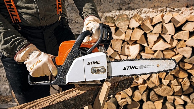 A person cutting a piece of wood with a Stihl MSE 170.
