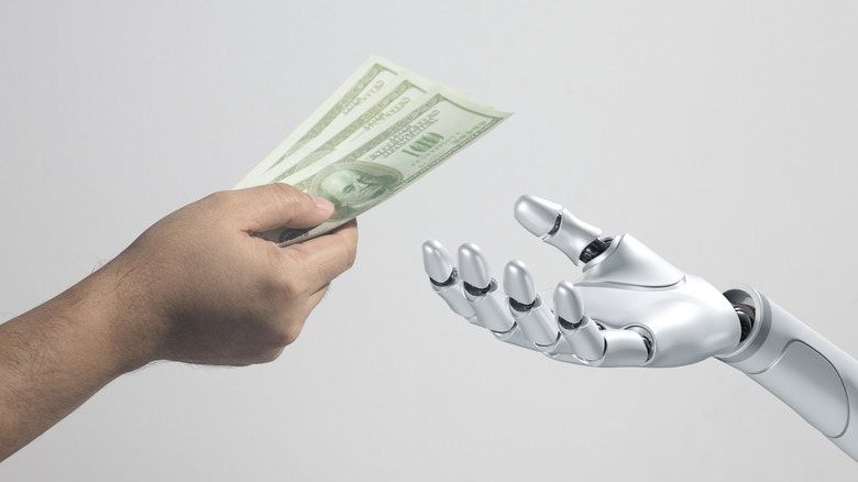 Human hand handing over bank notes to a robot hand