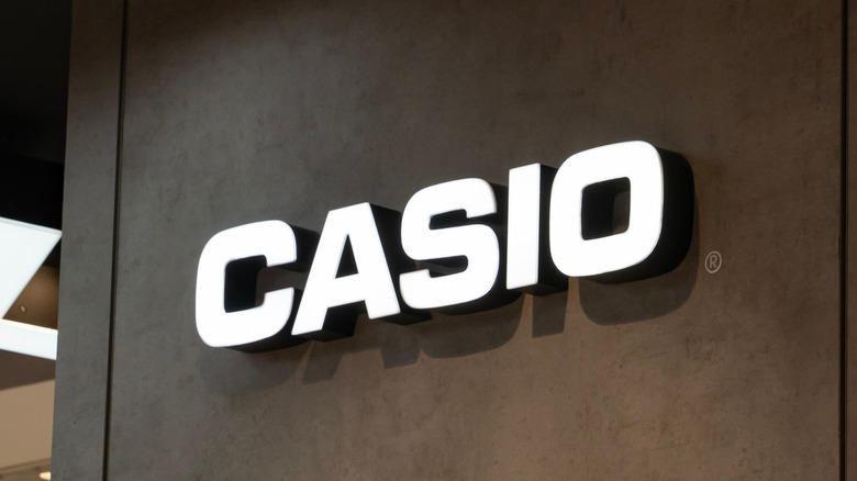 A white Casio logo on a black wall
