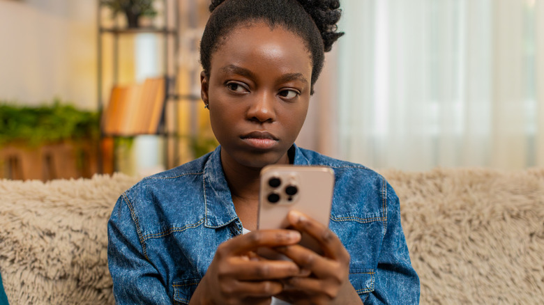 Visibly annoyed woman using an iPhone