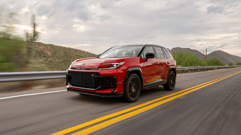 A red 2026 Toyota RAV4 PHEV GR Sport driving