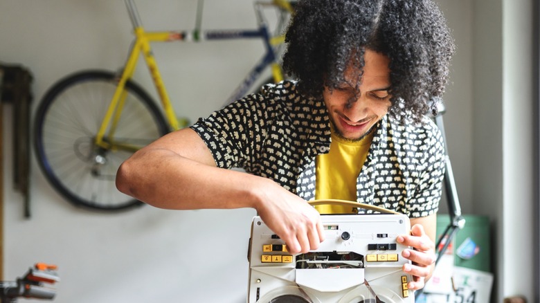Man fiddles with vintage cassette player