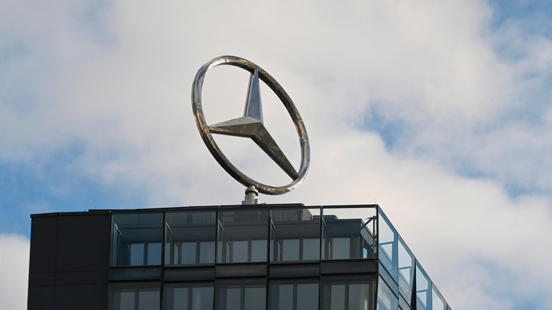Mercedes-Benz logo on top of building.