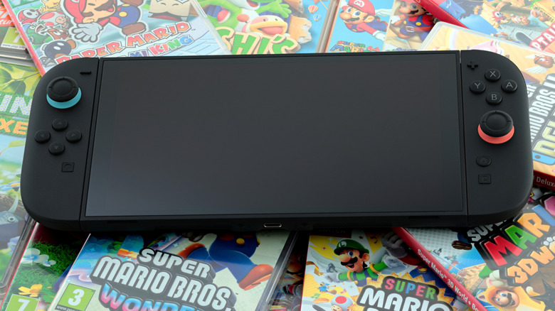 A Nintendo Switch 2 console is on top of a pile of games