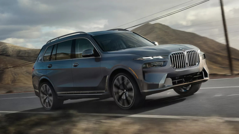 Blue-gray 2026 BMW X7 driving on a mountainous road