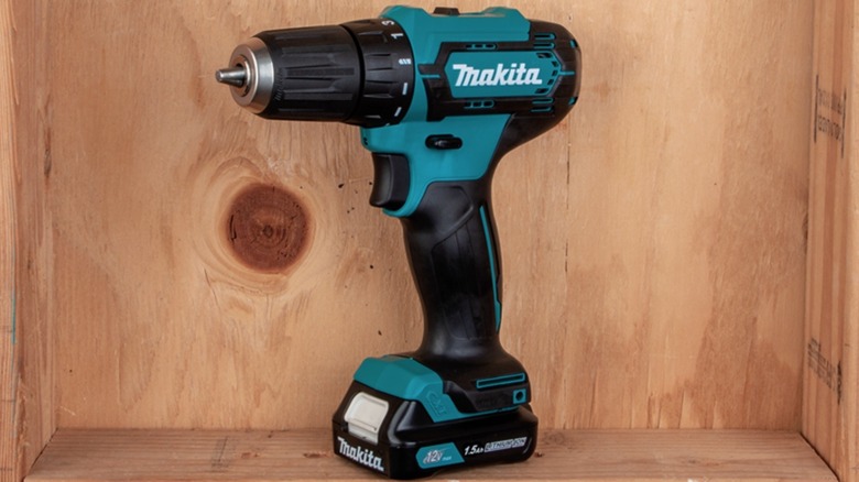 A Makita 12V power drill displayed in a light wood frame.