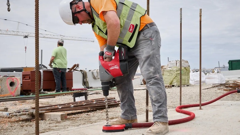 A person using a Milwaukee M18 demolition hammer.