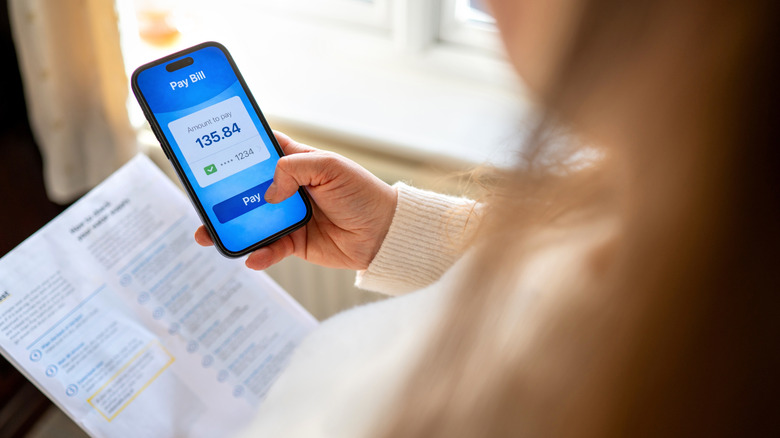 Person paying utility bill on phone