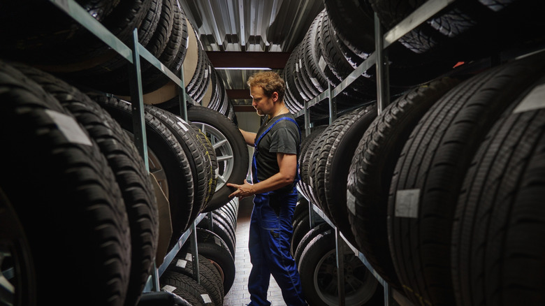Mechanic picking out a tire in a warehouse