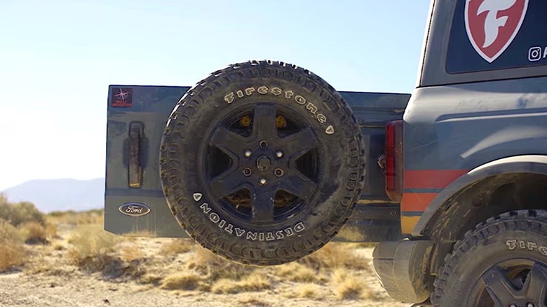 Firestone off road tire hanging on truck's rear gate