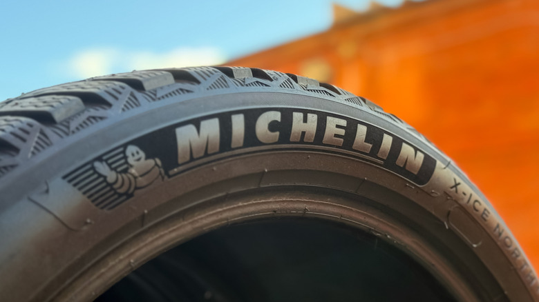 A Michelin tire against an orange and blue background.